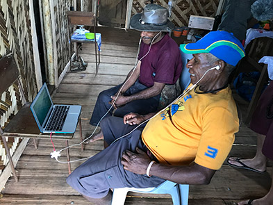 Ayasilo Heina and Gigiyo Weinabe watch playback of the film, Bona Village, Bosavi, December 2019